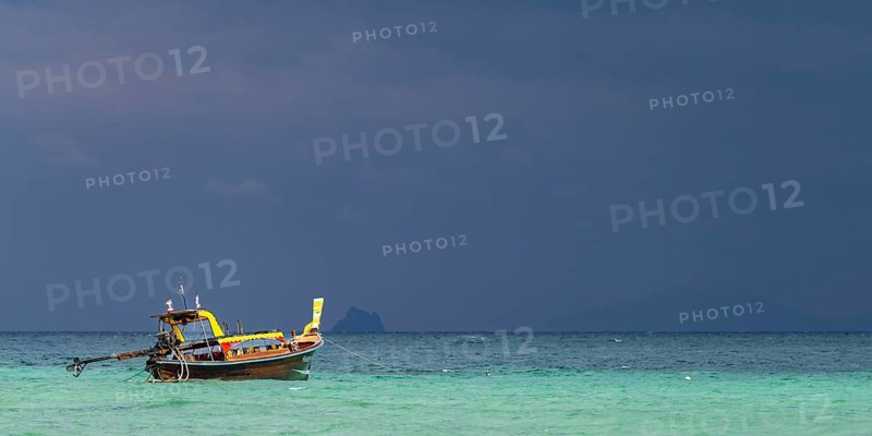 Longtail boat (Thai: Ruea Hang Yao) on the beach, behind it an approaching thunderstorm, Koh Ngai Island, Andaman Sea, Satun Province, Southern Thailand, Thailand