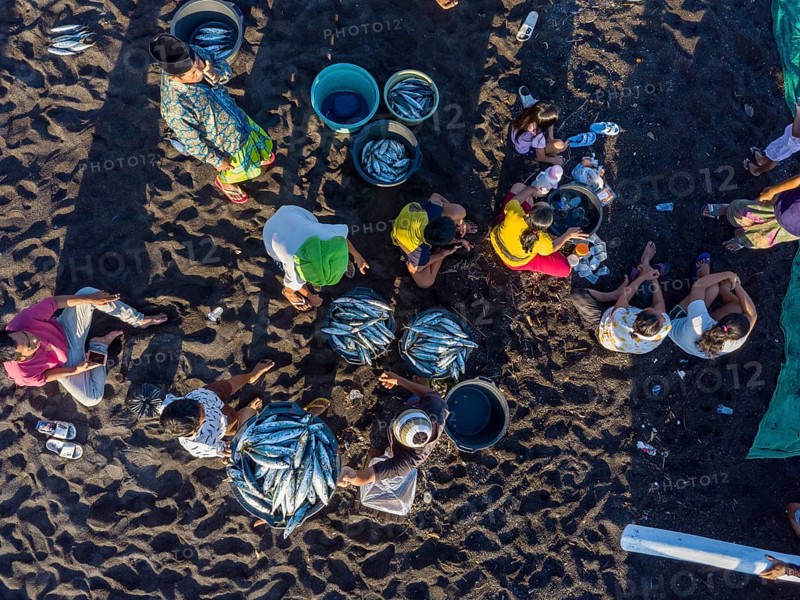 Fishermen unload their fish from their outrigger boat in the morning. Amed, Karangasem, Bali, Indonesia