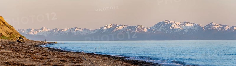 Boat on Anchor Point beach on Cook Inlet in the evening light, snowy mountain peaks of the Kenai Peninsula, Anchor River State Recreation Area, Alaska, USA