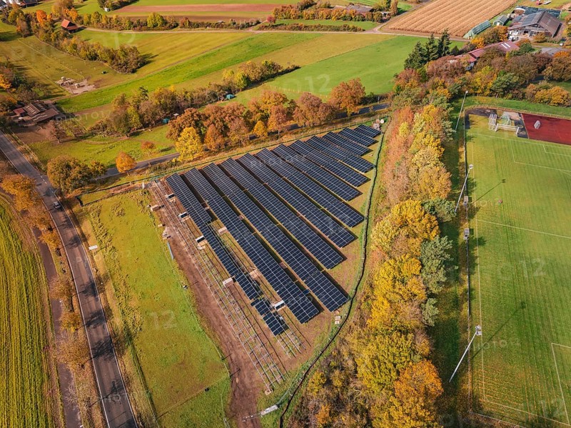 Aerial view of a solar field in an autumn landscape with fields and colorful trees, PV Freifaechenanlage construction, Weil der Stadt, Germany