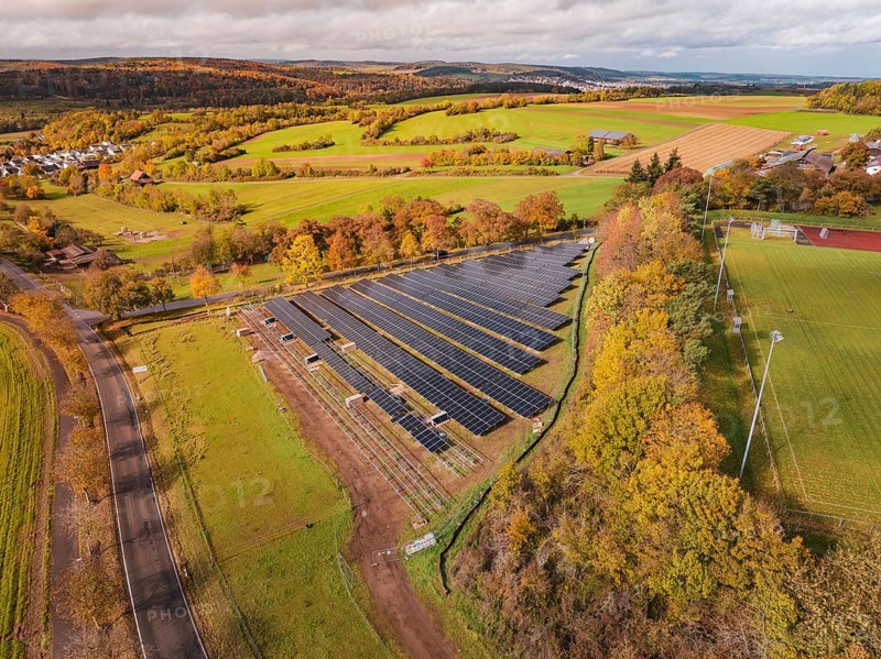 Large solar field in an autumn landscape, surrounded by green fields and trees, Bau PV Freifaechenanlage, Weil der Stadt, Germany