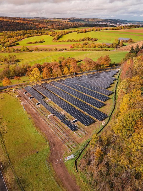 Aerial view of a large solar plant in an autumn landscape with fields and trees, PV Freifaechenanlage construction, Weil der Stadt, Germany