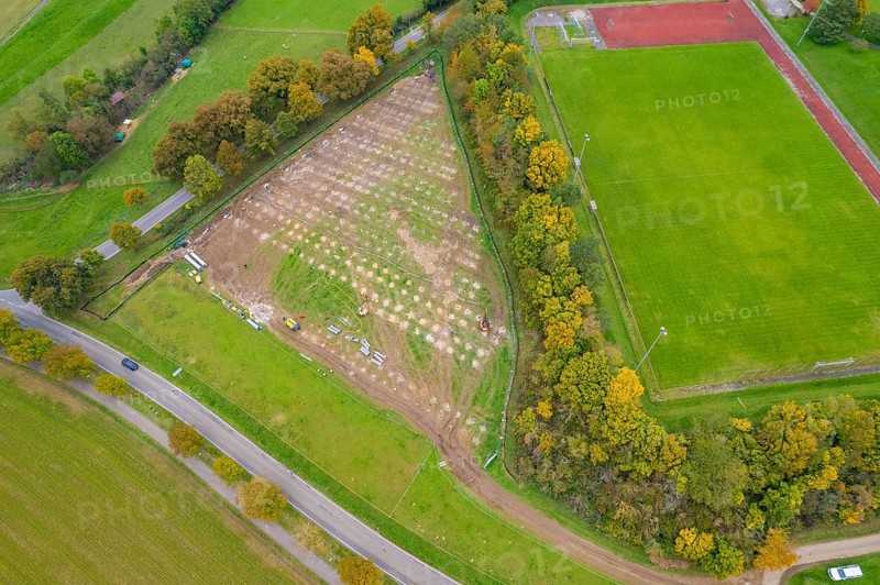 Aerial view of a large field next to a sports field, surrounded by autumn trees and roads, PV FreifÃ¤chenanlage building, Weil der Stadt, Germany