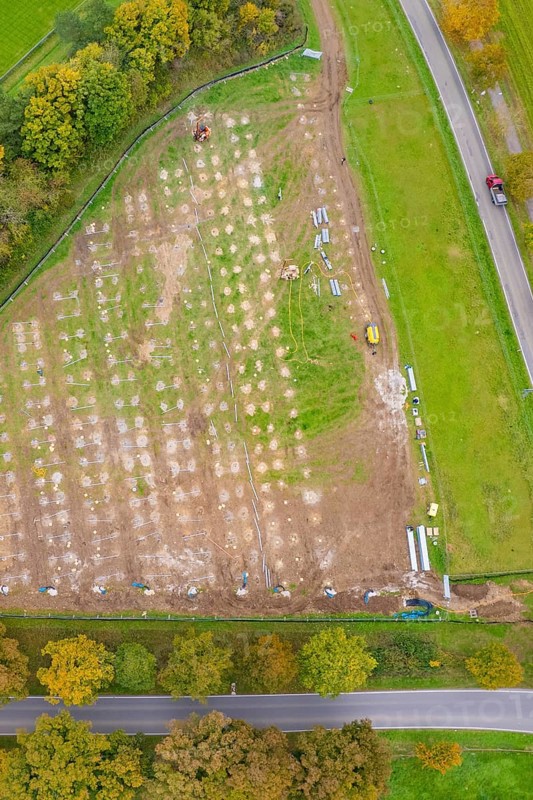 Aerial view of a large rectangular field with construction activities surrounded by autumn trees, PV Freifaechenanlage construction, Weil der Stadt, Germany