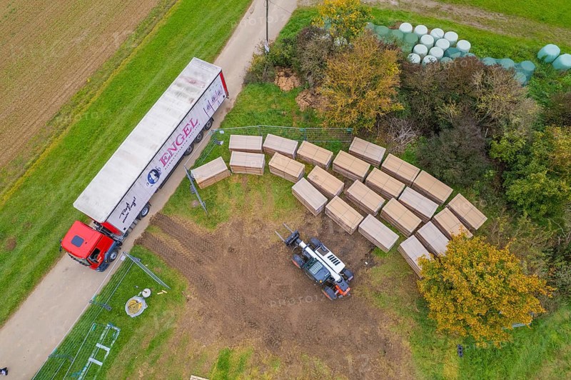 Aerial view of a forklift and truck in a colorful autumn landscape with boxes, construction PV Freifaechenanlage, Weil der Stadt, Germany