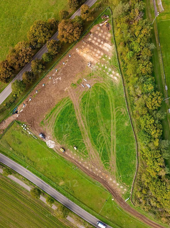 Aerial view of a green landscape with fences and roads surrounded by trees, construction of a PV open-air system, Weil der Stadt, Germany