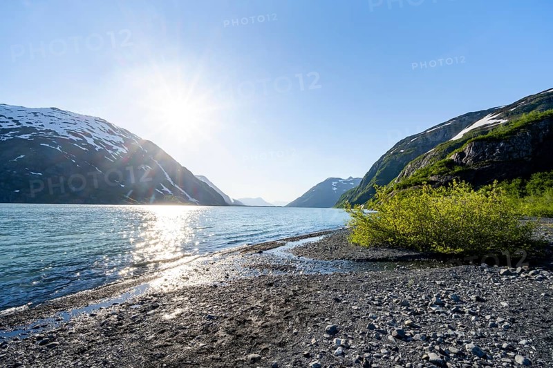 Landscape on glacial lake Portage Lake with sun star, Chugach National Forest, Alaska, USA