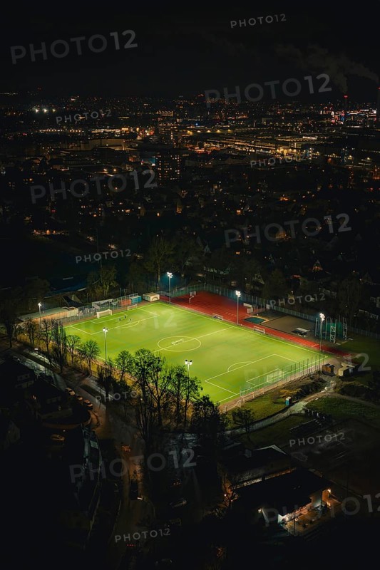 Illuminated soccer field in an urban area at night with glowing city lights, Sindelfingen, BÃ¶blingen district, Germany