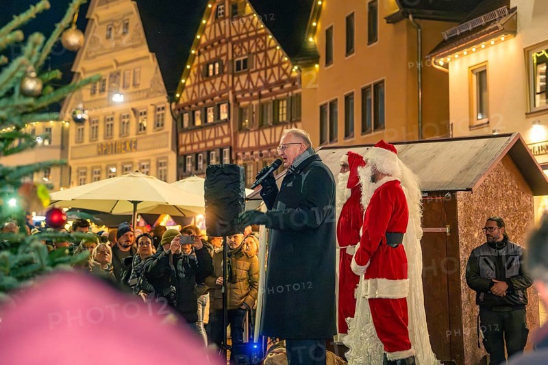 A man gives a speech next to Santa Claus on a market square with half-timbered houses, Christmas market 2025, Nagold, Black Forest, Calw district, Germany