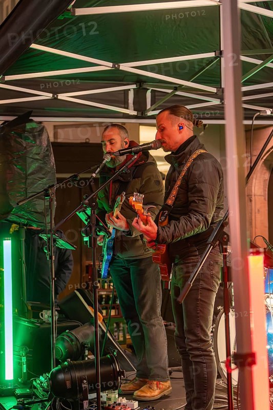 Two musicians on a stage at night playing guitars surrounded by festive lighting, Christmas market 2025, Nagold, Black Forest, Calw district, Germany