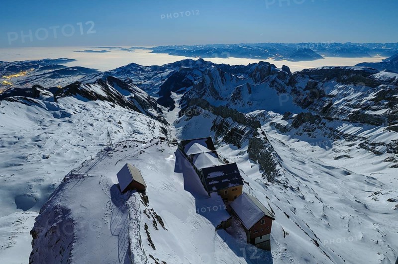 Night view, long exposure from 2506 meter high SÃ¤ntis down to the mountain gas houses of Alter SÃ¤ntis and the wintry, snow-covered Swiss and Austrian Alps, during a clear full moon night, Canton of Appenzell, Switzerland