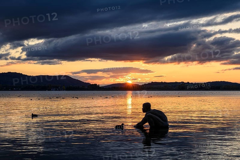 Bronze sculpture El NiÃ±o on the lakeside of Radolfzell am Lake Constance at sunset, Konstanz district, Baden-WÃ¼rttemberg, Germany
