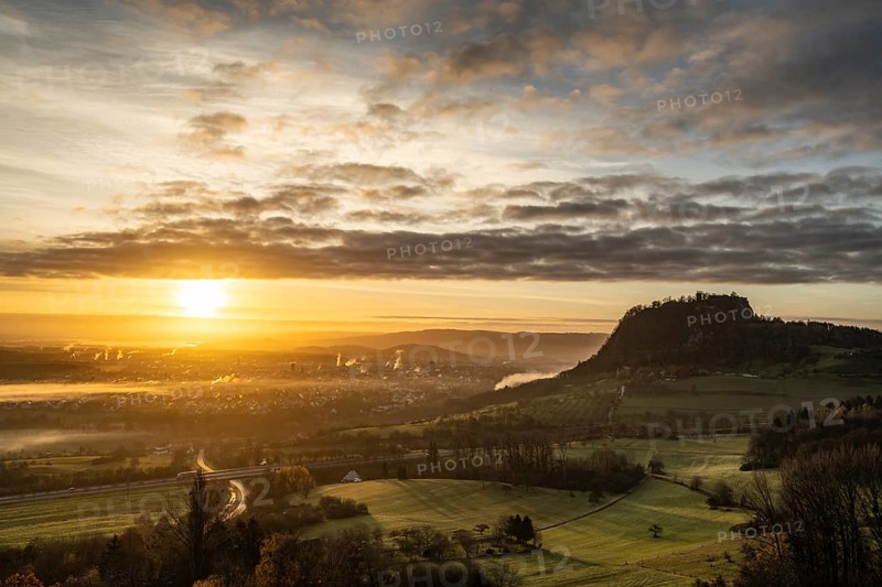 Sunrise with the Hohentwiel Hegau volcano, plumes of smoke from the burnt down historic bushel hall can be seen at the foot of the Hohentwiel, district of Constance, Baden-WÃ¼rttemberg, Germany