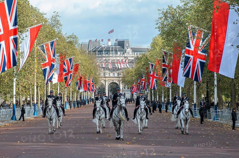 Mounted police with Union Jack flags on The Mall, behind the Admiralty Arch, Arc de Triomphe