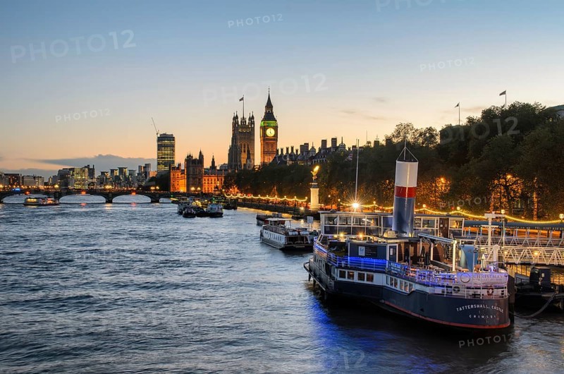 View over the Thames at golden hour with the Palace of Westminster and Elizabeth Tower, Big Ben, a moored ship in front of it, converted into a floating bar and restaurant PS Tattershall Castle, London, England, Great Britain