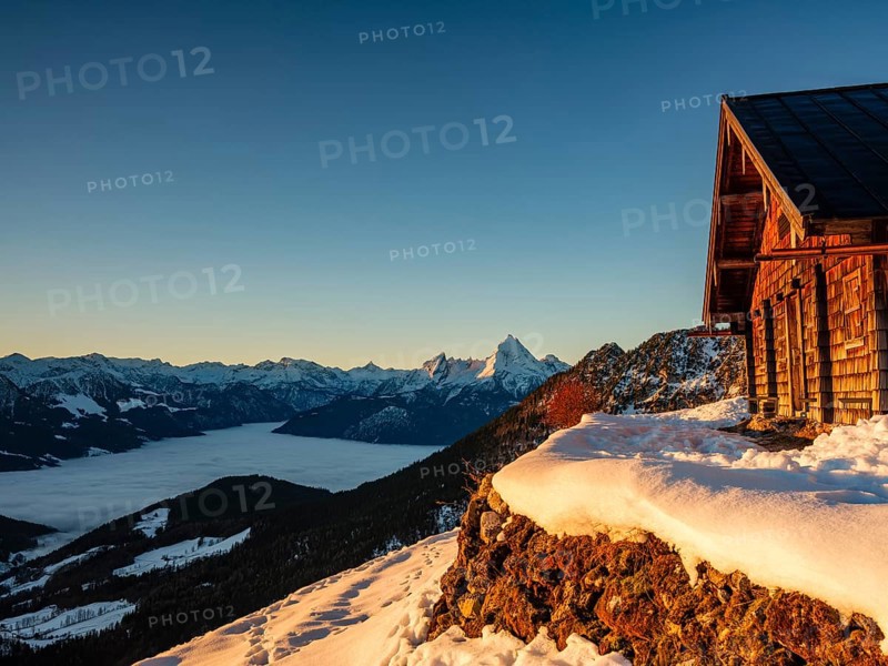 Alpine hut in winter at morning light, behind the Watzmann, fog in the valley, Berchtesgaden Alps, Scheibenkaser, Marktschellenberg, Berchtesgadener Land, Upper Bavaria, Bavaria, Germany