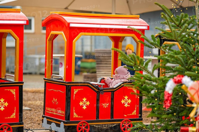 A child on a Christmassy decorated miniature train at a Christmas market, Sindelfingen, Böblingen district, Germany