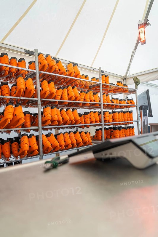 A tent with several shelves full of orange boots and a heater on the wall, Sindelfingen, Böblingen district, Germany
