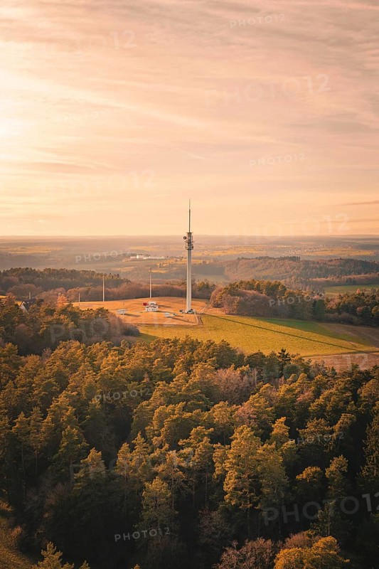 Bird's eye view of radio tower surrounded by thick forests at dusk, Gechingen, Hecken and GÃ¤u region, Calw district, Germany
