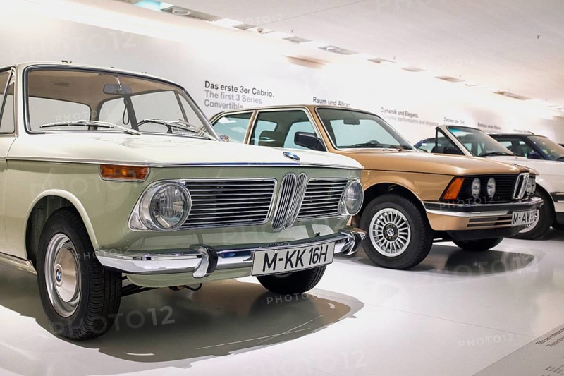 Classic BMW vehicles in the BMW Museum in Munich, In the foreground is a BMW 1600 built in 1966, it was the first vehicle of the legendary BMW 02 series, Behind it a BMW of the first 3 series (E21), which was introduced in 1975 and replaced the 02 series, Munich, Bavaria, Germany