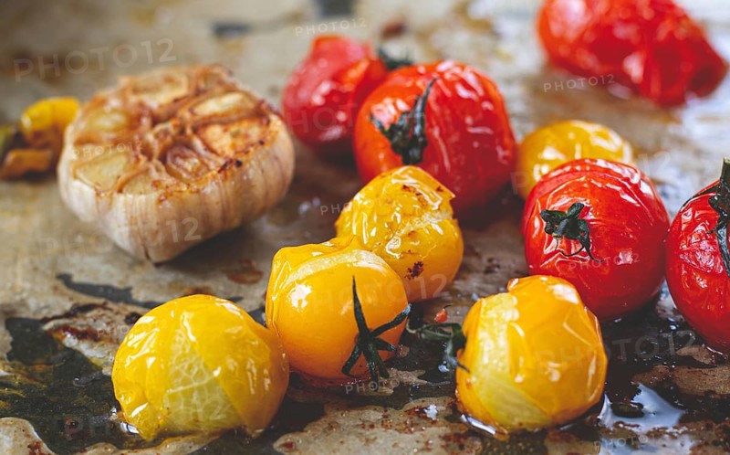 Baked cherry tomatoes, in the oven, on a baking sheet, with olive oil and spices, close-up, selective focus, homemade, no people