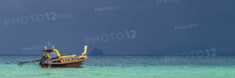 Longtail boat (Thai: Ruea Hang Yao) on the beach, behind it an approaching thunderstorm, Koh Ngai Island, Andaman Sea, Satun Province, Southern Thailand, Thailand