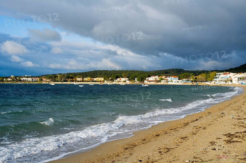 A beach with soft waves, cloudy skies and houses along the coast, beach near GÃ¼zelyali, GÃ¼zelyalÄ±, Ã‡anakkale, Canakkale, Marmara region, Turkey