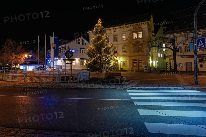 A festively lit Christmas tree on a side of the street at night, Aidlingen, Böblingen district, Germany