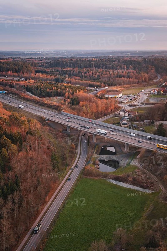 Junction of roads surrounded by forests, at dusk, showing rural transport infrastructure, A8 motorway, Germany