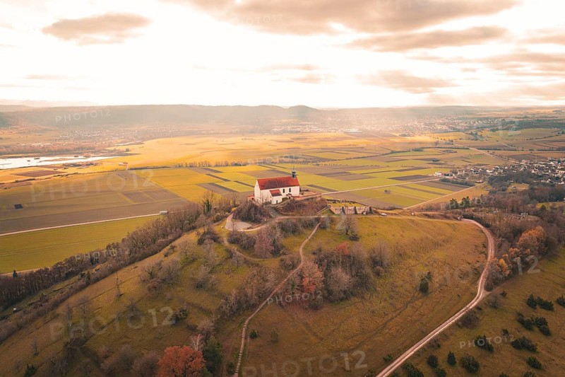 Panoramic view of a church on a hill with surrounding fields and vast clouds, Wurmlinger Chapel, Rottenburg am Neckar, Germany