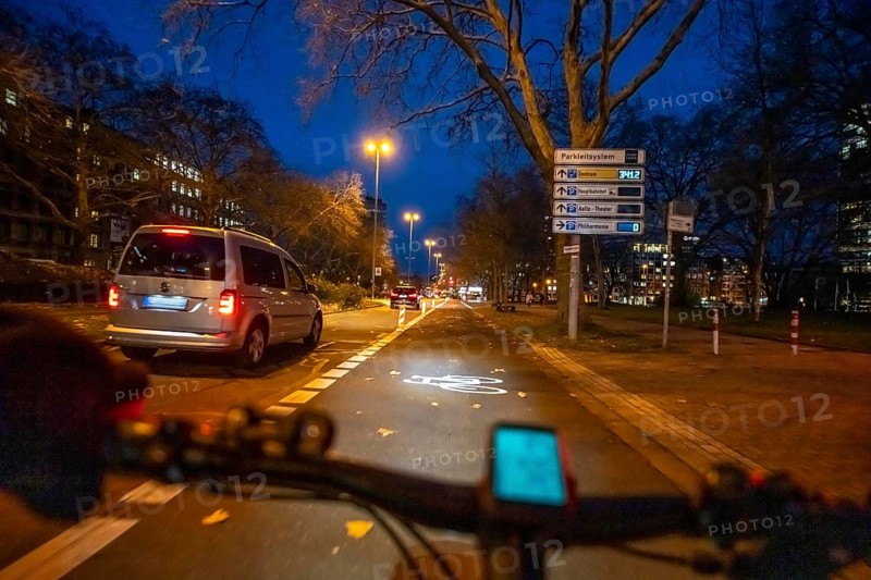 Cycling in the city, in the dark, in the evening, cycling on a bike lane, Huyssenallee, in front of Europaplatz, in downtown Essen, North Rhine-Westphalia, Germany