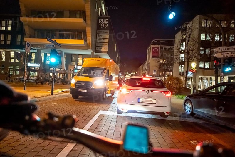 Cycling in the city, in the dark, in the evening, cycling on a bike lane, marked, between 2 lanes, Huyssenallee, in downtown Essen, North Rhine-Westphalia, Germany