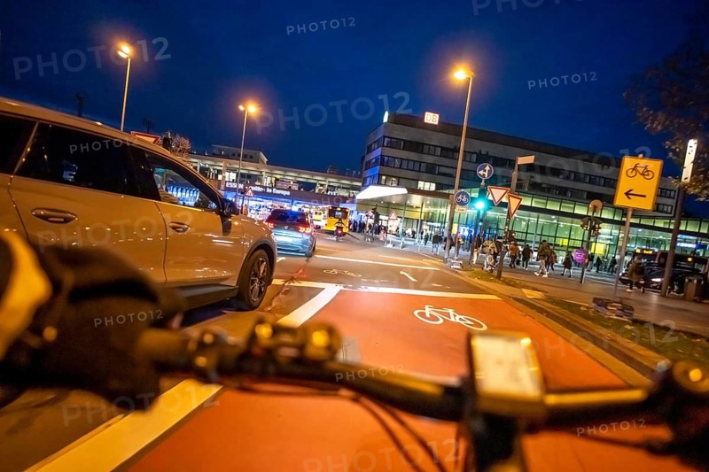 Cycling in the city, in the dark, in the evening, cycling on a bike lane, marked in red to alert drivers to the cycle path, between 2 lanes, Huyssenallee, in front of Europaplatz, in downtown Essen, North Rhine-Westphalia, Germany