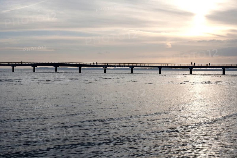 Silhouettes of people on a pier, sunrise, Scharbeutz, 29.11.2025, Scharbeutz, Schleswig-Holstein, Germany