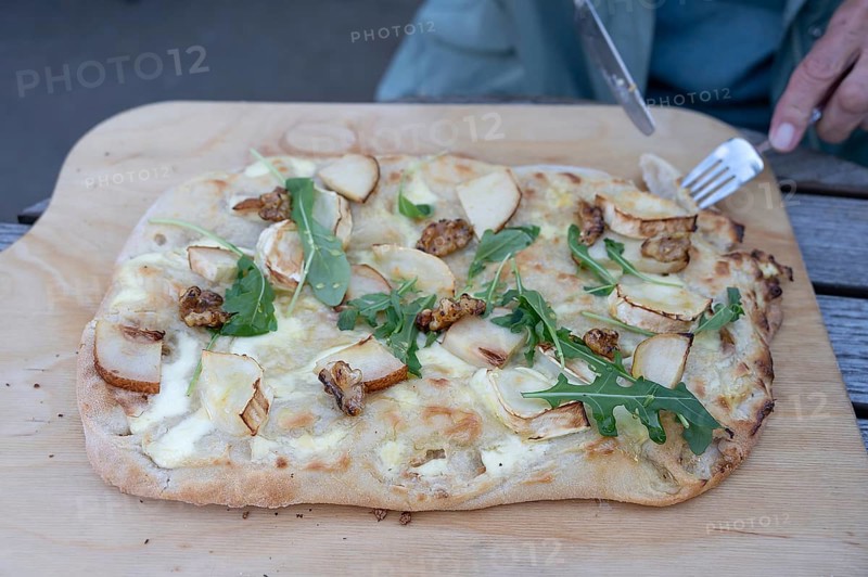 Flammkuchen with goat cheese, pears and nuts served on a wooden board, Ahrenshoop, DarÃŸ, Mecklenburg-Western Pomerania, Germany