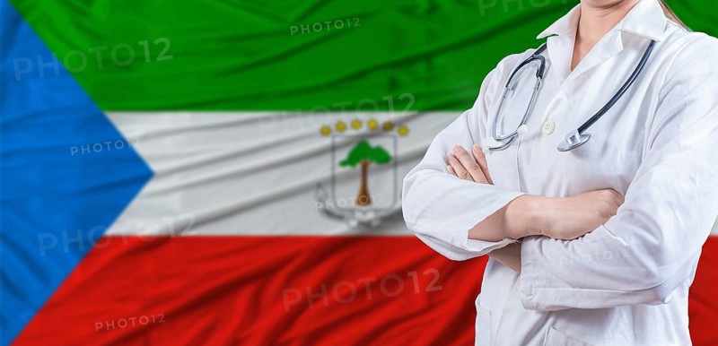 Doctor with crossed arms on Equatorial Guinea flag. Equatorial Guinean health and care concept. Female doctor on Equatorial Guinea flag