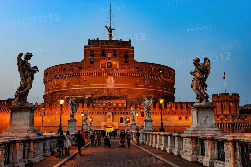 View of blue hour at nightfall in 139 AD as an ancient mausoleum Hadrian Tomb for Emperor Caesar Emperor Hadrian built Castel Sant'Angelo Sant'Angelo on the banks of the Tiber, in front of Ponte degli Angeli Angel Bridge with statues of winged beings angels, Rome, Lazio, Italy