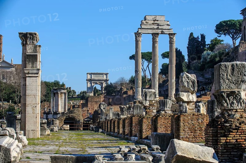 View of Roman Forum through the middle of ruin with foundations of Basilica Basilica Julia Julia right behind the remaining three columns of Dioscuri Temple Temple of Castor and Pollux center back right Arch of Titus triumphal arch of Emperor Titus left next to the ruins of Temple of the Vestals, Roman Forum, Rome, Lazio, Italy