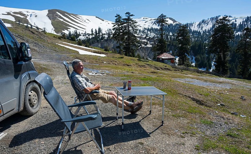 A man relaxing next to a van in a sunny mountain landscape, view from Goderdzi Pass, Ajara region, Adjara, Autonomous Republic, Georgia