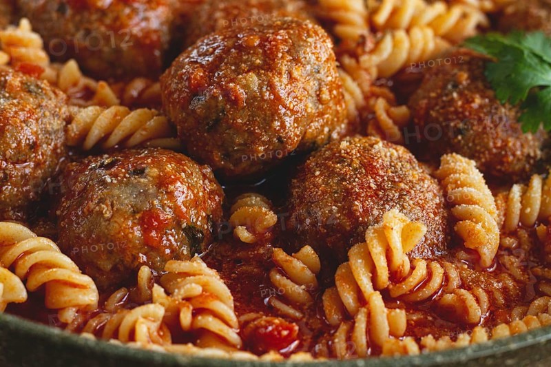 Minced meat meatballs, in tomato sauce, with fusilli pasta, in a cast-iron pan, homemade, no people