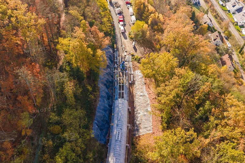 Overview of a tunnel construction site in autumn forest from an oblique bird's eye view, Hermann Hesse Railway bat tunnel construction site, Calw, Black Forest, Germany