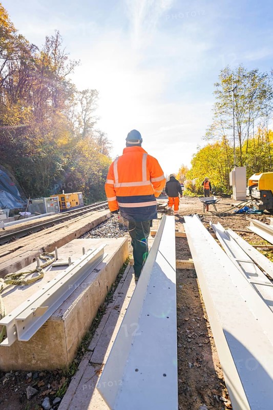 Construction workers in protective clothing walk along a construction site in an autumn scene, Hermann Hesse Railway bat tunnel construction site, Calw, Black Forest, Germany
