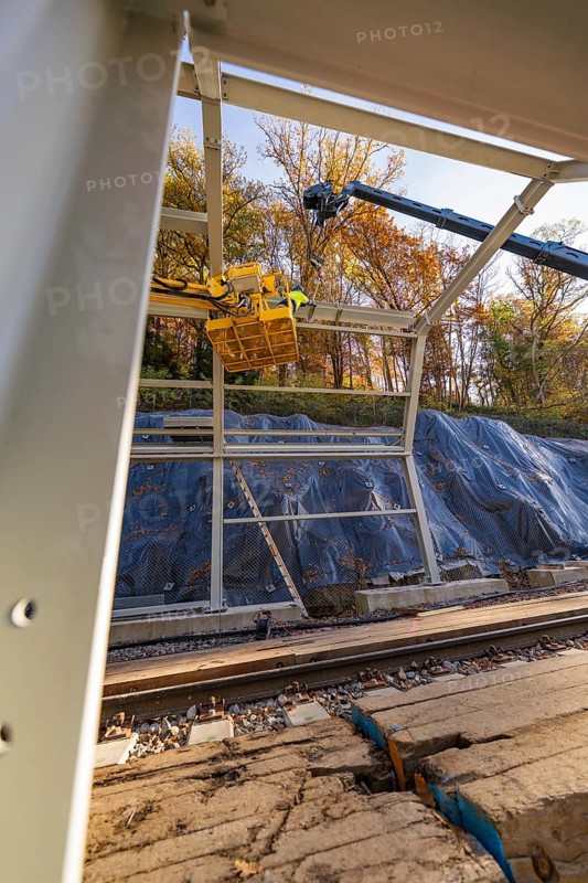 Metal frame construction with crane over tracks in an autumn environment with forest in the background, Hermann Hesse Railway bat tunnel construction site, Calw, Black Forest, Germany