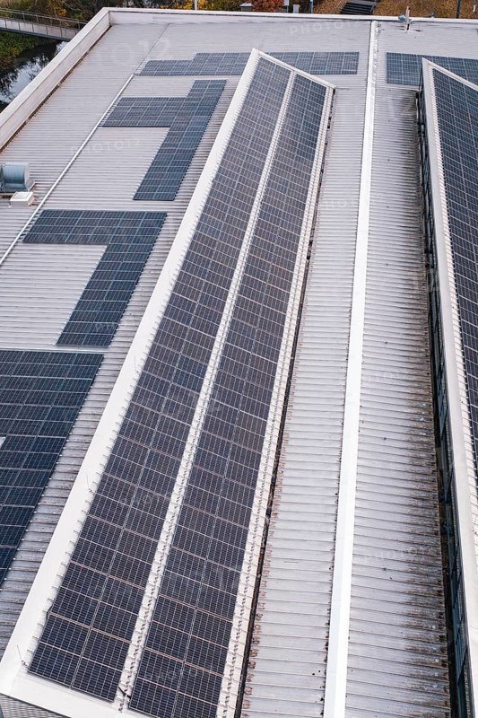 Close-up of a roof with two rows of solar cells, including some technical details, PV on Walther Lindner Sporthalle Calw, Black Forest, Germany