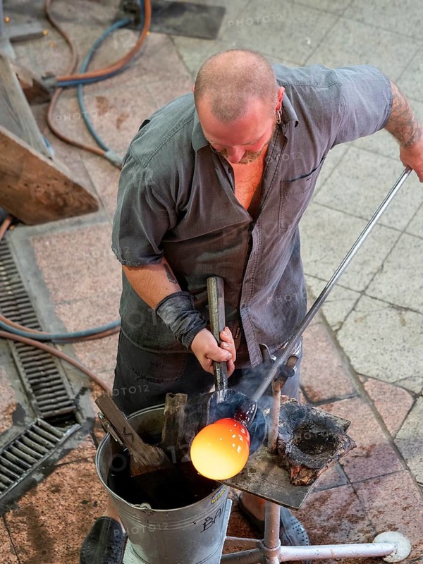 Glassblowers at work, forming and processing molten glass, Bohemia, Czech Republic