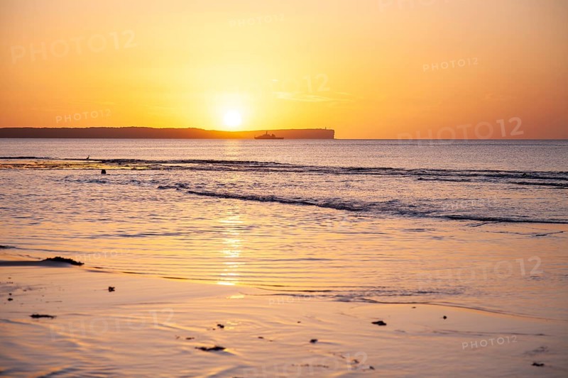 Sunrise over Jervis Bay â€” View of Point Perpendicular lighthouse. A ship on the horizon