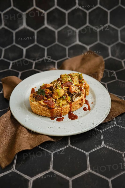 A mouthwatering mushroom sandwich topped with honey mushrooms, enoki mushrooms, and champignon rests on a rustic plate
