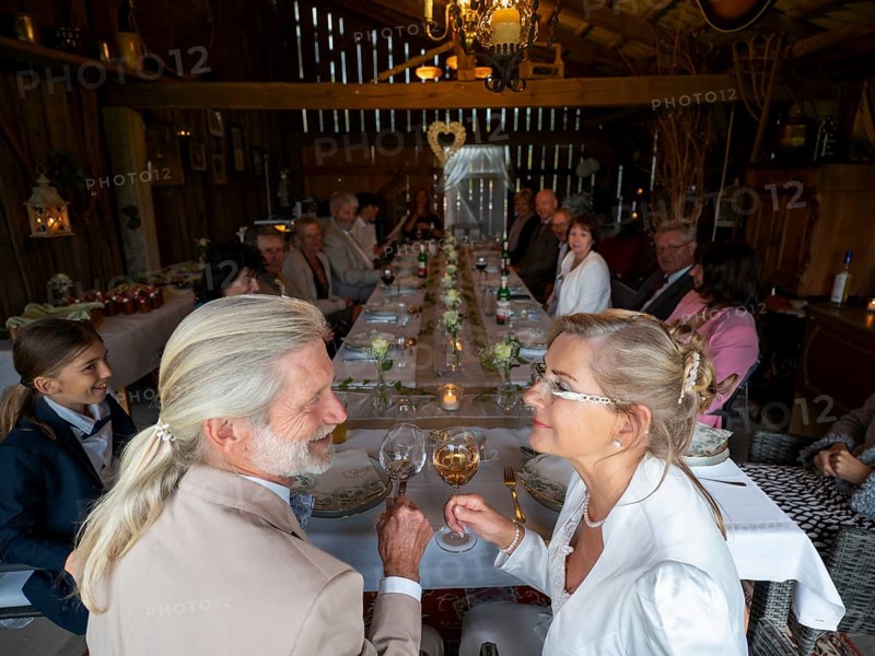 Elderly couple's wedding, with wedding party in an old barn
