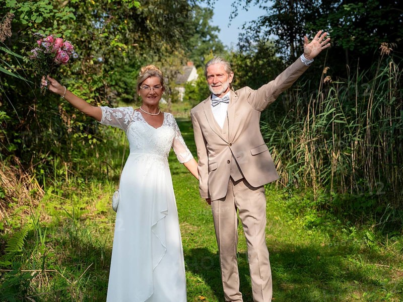 Elderly couple's wedding on a green meadow path