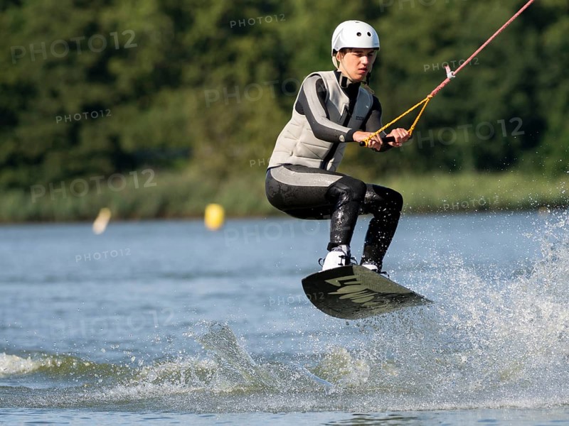 Young man with wakeboard, jumping on water, water sports, wake park